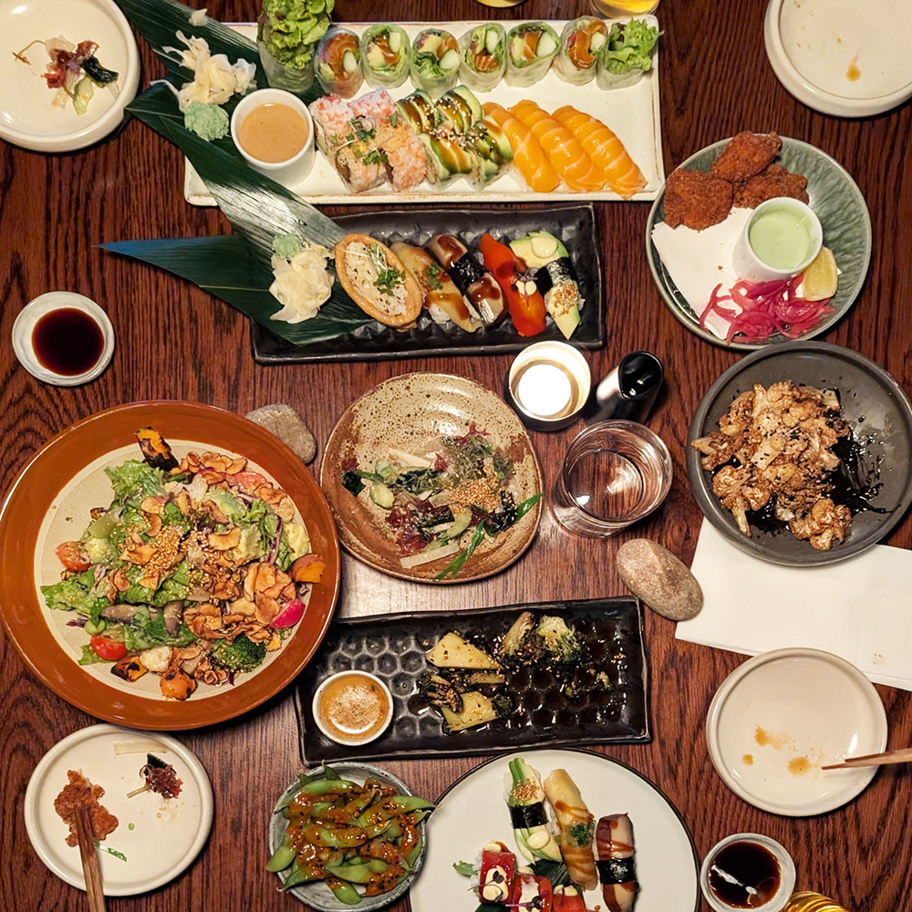 251106 Sow Space summer social_1 A top down view of a tableful of colourful Japanese food and drink